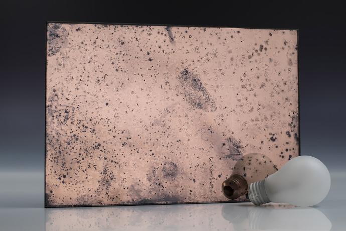 Fine copper grain - copper - antique mirror - sample A square piece of copper mirror with a patina and a light bulb on a neutral background