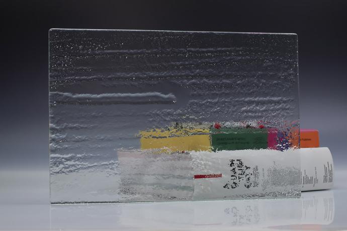 A square piece of clear texture glass and a book on a neutral background