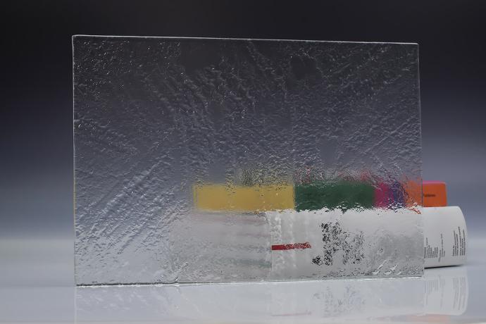 A square piece of clear texture glass and a book on a neutral background