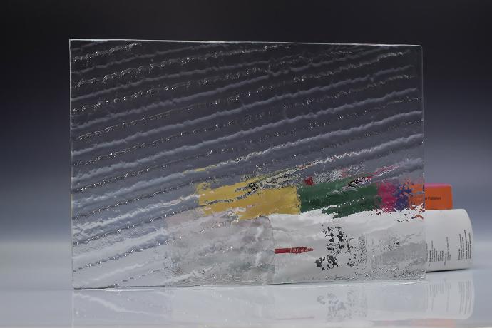 A square piece of clear texture glass and a book on a neutral background