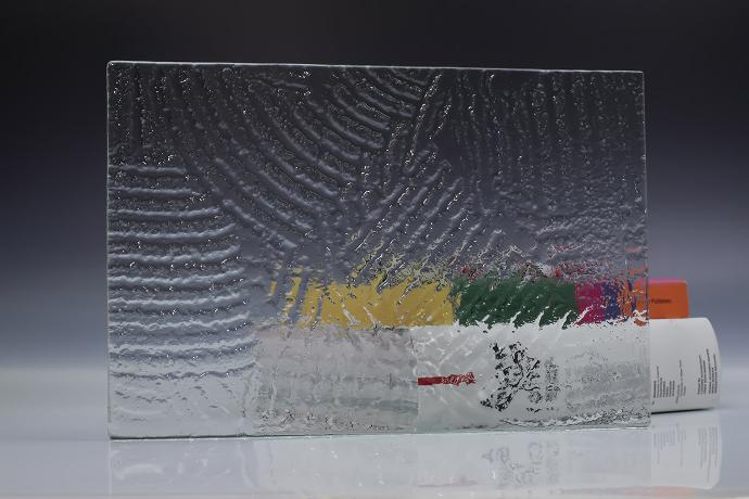 A square piece of clear texture glass and a book on a neutral background