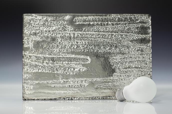 A square piece of texture silver colored glass and light bulb on a neutral background