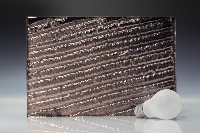 Copper oxide - metallic - reljefno staklo - uzorak Četverokutni komad reljefnog stakla boje bakra i žarulja na neutralnoj pozadini