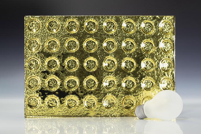  A square piece of gold-colored texture glass and a light bulb on a neutral background