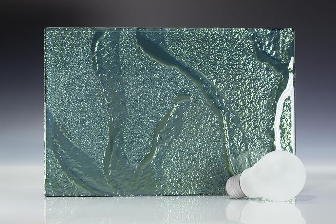 Emerald green - terrestrial - reljefno staklo - uzorak Četverokutni komad reljefnog stakla zelene boje i žarulja na neutralnoj pozadini