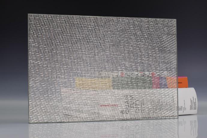 A square piece of glass with silver mesh and books on a neutral background