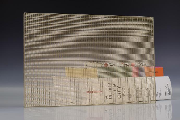Četverokutni komad stakla sa zlatnom mrežicom i knjige na neutralnoj pozadini