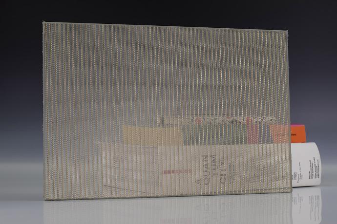 Četverokutni komad stakla sa zlatnom mrežicom i knjige na neutralnoj pozadini