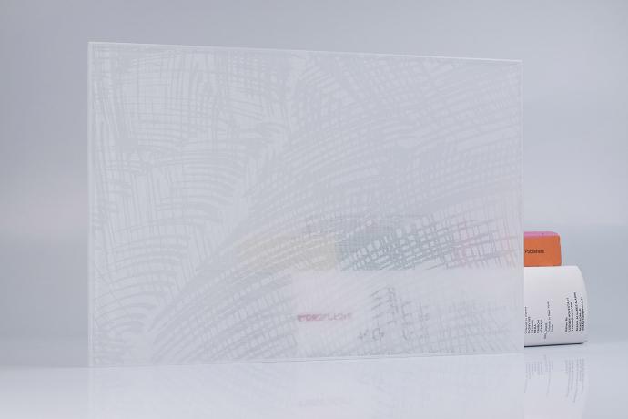 A square piece of glass with a white textile and books on a neutral background