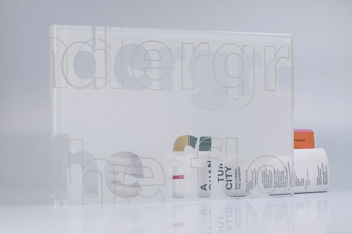 Square piece of glass with white textile with letters and books on a neutral background
