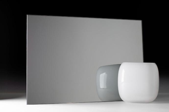 A square piece of mirror and a bowl on a dark background