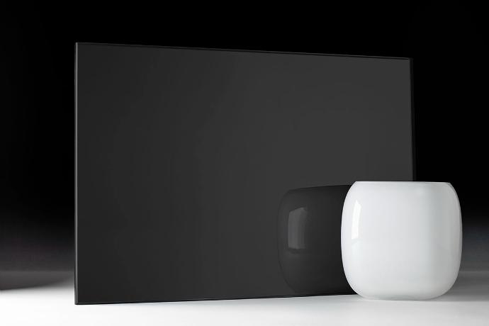 A square piece of dark grey mirror and a bowl on a dark background