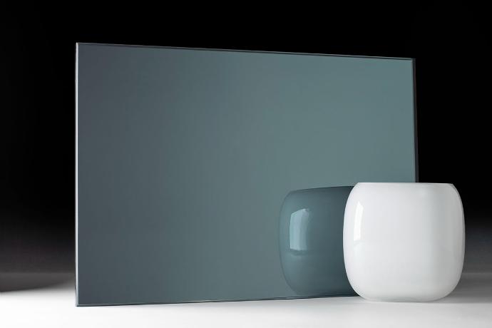 A square piece of dark green mirror and a bowl on a dark background