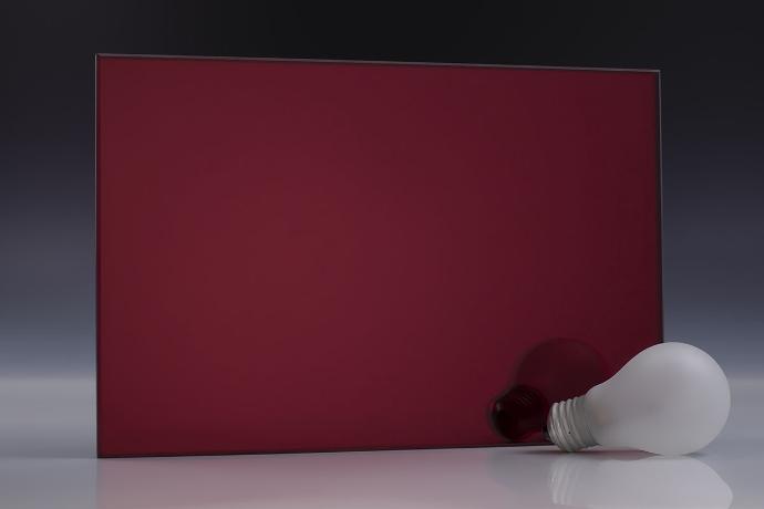 Echo red - color laminated mirrors - stakla i ogledala u boji - uzorak Četverokutni komad tamnocrvenog ogledala i knjige na neutralnoj pozadini