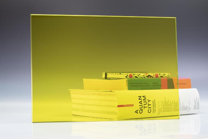 Yellow - color transparent glass - stakla i ogledala u boji - uzorak Četverokutni komad žutog transparentnog stakla i knjige na neutralnoj pozadini