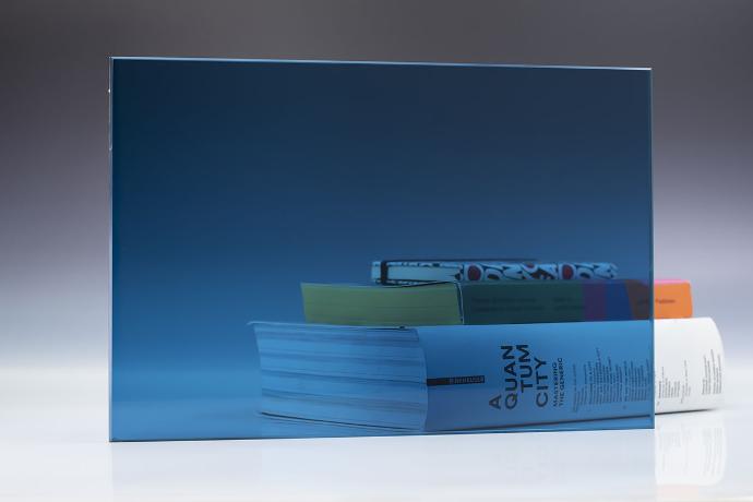 Blue - color transparent glass - stakla i ogledala u boji - uzorak Četverokutni komad plavog transparentnog stakla i knjige na neutralnoj pozadini