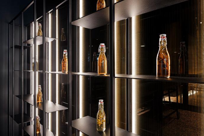 Moderno dizajnirana, osvijetljena izložbena polica s bocama pića