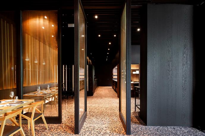 Moderni interijer restorana sa staklenim vratima, stolom i stolicama