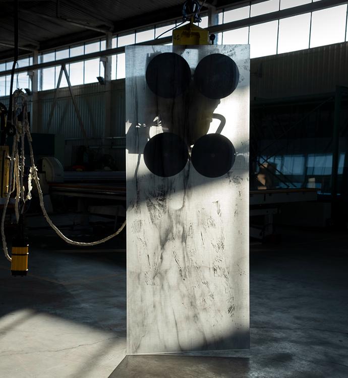 The semi-dark interior of the factory hall with a large piece of transparent glass