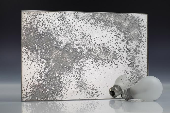 Silver white oxide - silver oxidation - antique mirror - sample A square piece of mirror with a patina effect and light bulbs on a neutral background