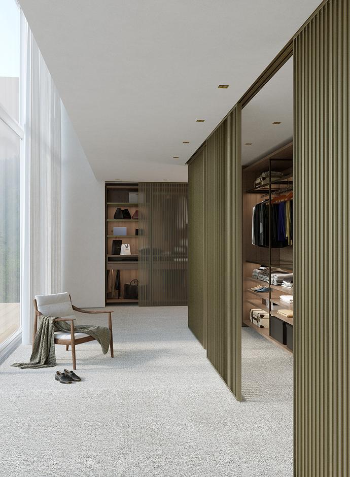 Modern interior with an armchair and a walk-in closet with glass doors.