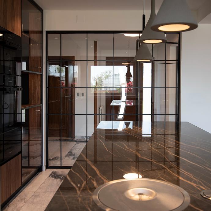 Modern kitchen with a glass partition.