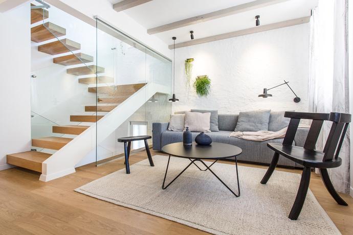Modern bright interior with stairs, coffee table, armchair and sofa