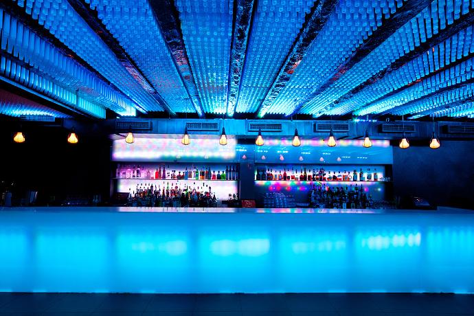 A glass bar in a modern interior, illuminated by blue light