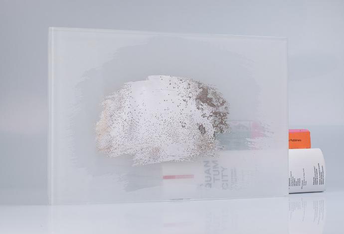 A square piece of white glass with a partial mirror and books on a light background