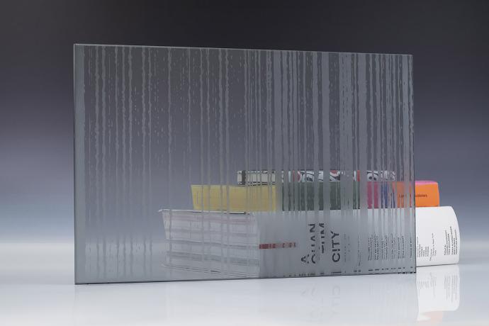 A square piece of patterned etch glass and books on a neutral background