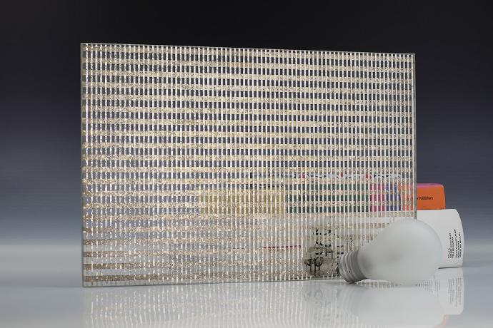 A square mirror piece with a linear pattern, a light bulb and books on a neutral background