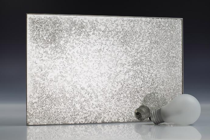 Silver white grain - silver oxidation - antique mirror - sample A square piece of mirror with a pronounced patina effect and light bulbs on a neutral background