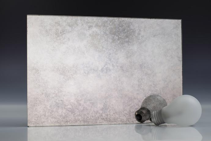 Silver smooth sediment - silver sedimentation - antique mirror - sample A square piece of mirror with a patina effect and light bulbs on a neutral background
