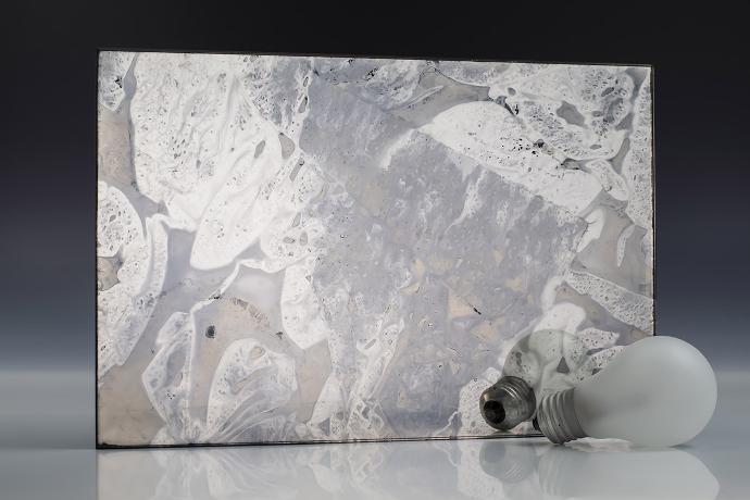 Double silver sediment - silver sedimentation - antique mirror - sample A square piece of mirror with a pronounced patina effect and light bulbs on a neutral background