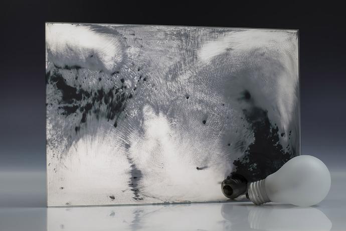 Open silver sediment - silver sedimentation - antique mirror - sample A square mirror piece with dark spots and a light bulb on a neutral background